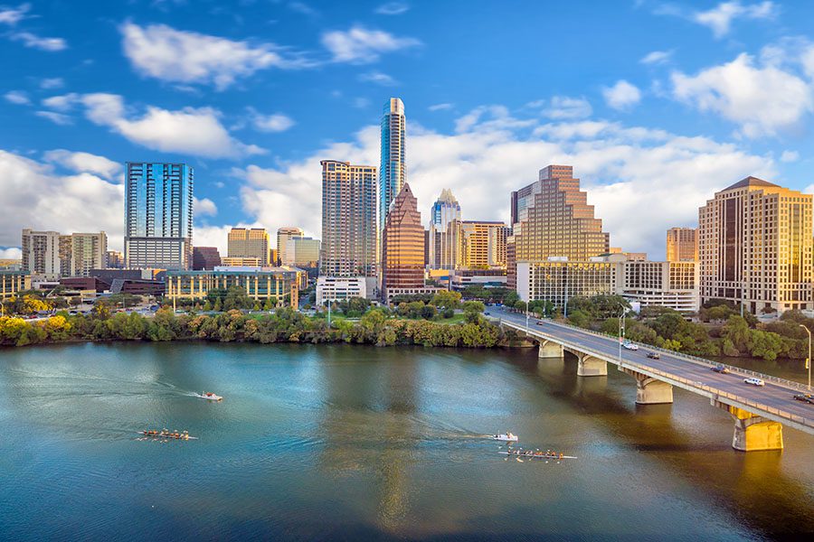 Contact - View of Downtown Skyline of Austin Texas Displaying Many Tall Buildings With a Bridge Over a Large Body of Water